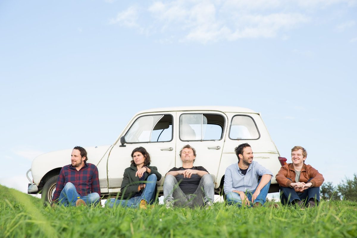 Siklenda Band – fünf MusikerInnen vor einem weißen Oldtimer auf einer Wiese